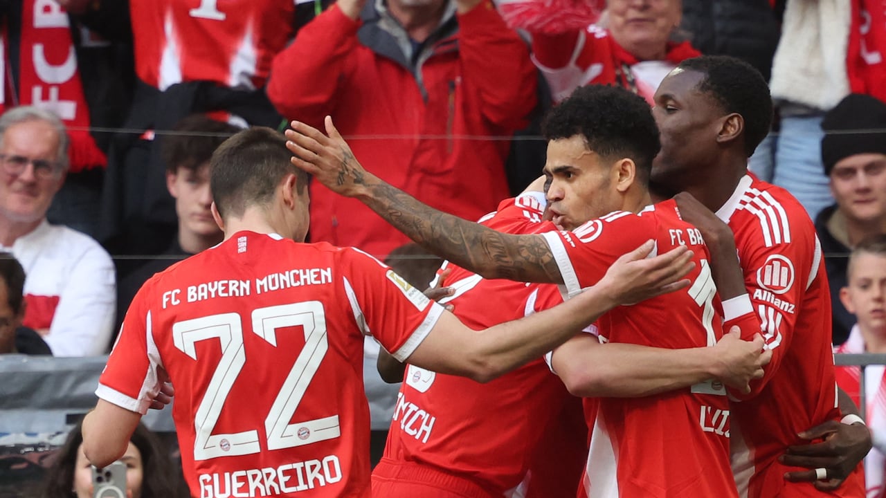 El defensa portugués del Bayern de Múnich, Raphael Guerreiro (izq.), número 22, celebra con sus compañeros, entre ellos Luis Díaz (segundo de derecha a izquierda) tras marcar el gol del empate (1-1) durante el partido de la Bundesliga, la primera división alemana, entre el FC Bayern de Múnich y el VfB Stuttgart en Múnich, al sur de Alemania, el 19 de abril de 2026. (Foto de Karl-Josef HILDENBRAND / AFP)