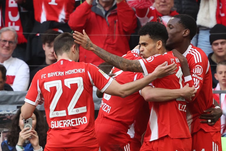 El defensa portugués del Bayern de Múnich, Raphael Guerreiro (izq.), número 22, celebra con sus compañeros, entre ellos Luis Díaz (segundo de derecha a izquierda) tras marcar el gol del empate (1-1) durante el partido de la Bundesliga, la primera división alemana, entre el FC Bayern de Múnich y el VfB Stuttgart en Múnich, al sur de Alemania, el 19 de abril de 2026. (Foto de Karl-Josef HILDENBRAND / AFP)