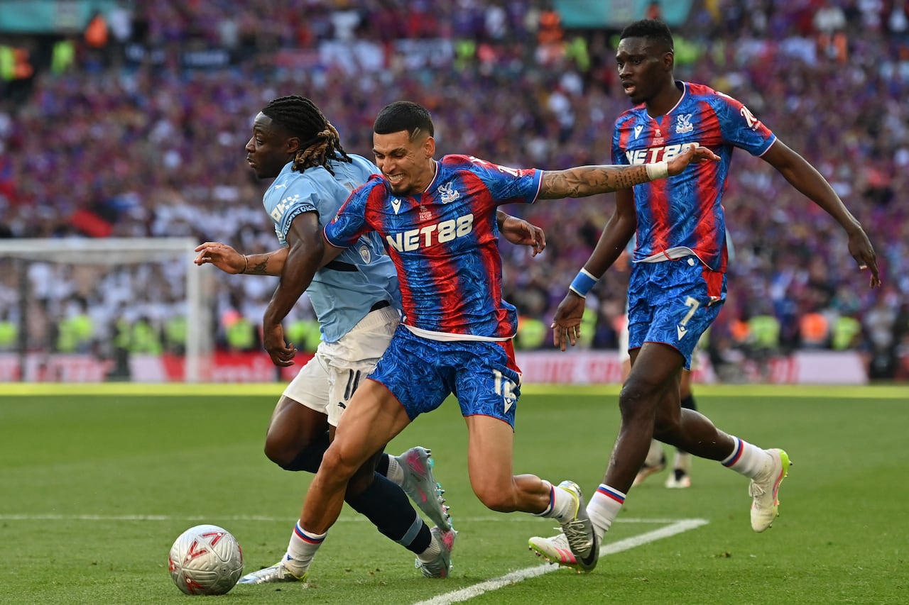 El centrocampista belga #11 del Manchester City Jeremy Doku (L) compite con el defensor colombiano #12 del Crystal Palace Daniel Muñoz (C) durante la final de la Copa FA inglesa.
