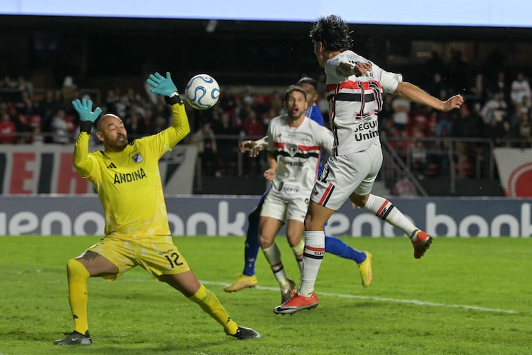 El delantero de Sao Paulo #11 Ferreira encabeza el balón contra el portero de Millonarios #12 Diego Novoa durante el partido de fútbol de la fase de grupos de la Copa Sudamericana entre el Sao Paulo de Brasil y los Millonarios de Colombia en el estadio Morumbi en Sao Paulo, Brasil, el 19 de mayo de 2026. (Foto de NELSON ALMEIDA / AFP)