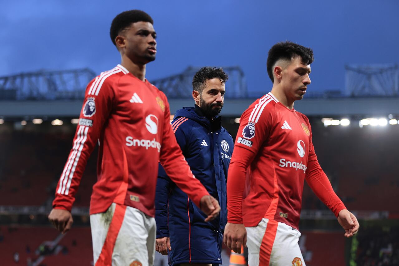 MANCHESTER, ENGLAND - DECEMBER 22: Manchester United manager Ruben Amorim walks off between Amad Diallo of Manchester United (L) and Lisandro Martinez of Manchester United after the Premier League match between Manchester United FC and AFC Bournemouth at Old Trafford on December 22, 2024 in Manchester, England. (Photo by Simon Stacpoole/Offside/Offside via Getty Images)