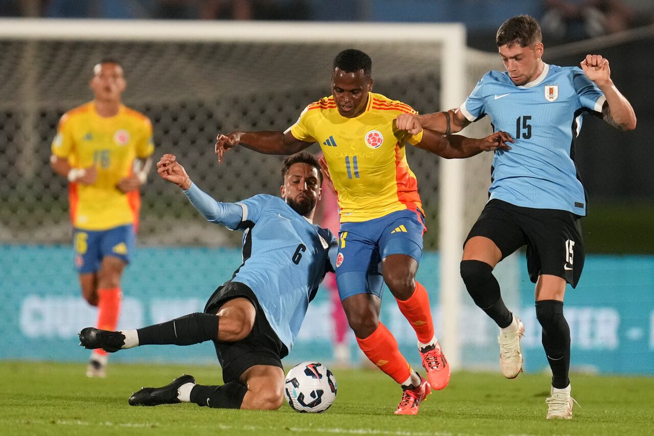 Los uruguayos Rodrigo Bentancur (6), Federico Valverde (15) y el colombiano Jhon Arias disputan el balón durante un partido de clasificación para la Copa Mundial de la FIFA 2026 en Montevideo, Uruguay, el viernes 15 de noviembre de 2024. (Foto AP/Matilde Campodonico)