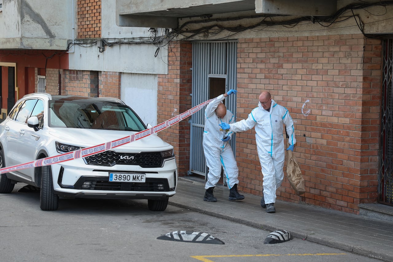 Agentes de la policía forense española entran al edificio para hacer el levantamiento de los cuerpos de los adolescentes fallecidos en el incendio.