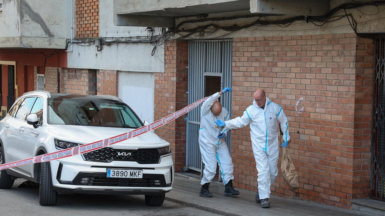 Agentes de la policía forense española entran al edificio para hacer el levantamiento de los cuerpos de los adolescentes fallecidos en el incendio.