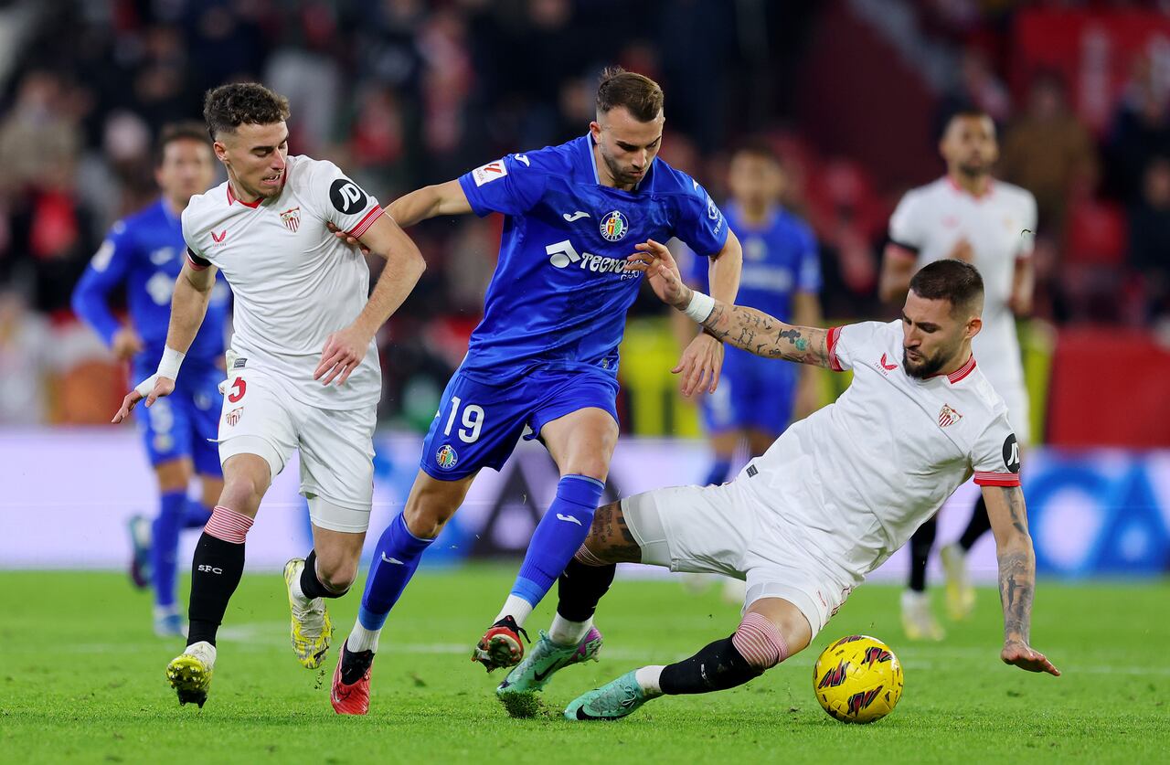 SEVILLA, ESPAÑA - 16 DE DICIEMBRE: Nemanja Gudelj (R) y Adria Pedrosa del Sevilla FC (R) se enfrentan a Borja Mayoral del Getafe CF durante el partido de La Liga EA Sports entre el Sevilla FC y el Getafe CF en el Estadio Ramón Sánchez Pizjuan el 16 de diciembre de 2023 en Sevilla, España. (Foto de Fran Santiago/Getty Images)