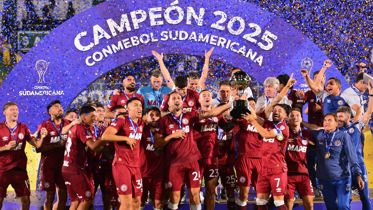 El defensa #24 de Lanús, Carlos Izquierdoz, y el delantero #07, Lautaro Acosta, levantan el trofeo junto a sus compañeros tras ganar la final de la Copa Sudamericana entre Lanús de Argentina y Atlético Mineiro de Brasil en el estadio Defensores del Chaco en Asunción el 22 de noviembre de 2025. (Foto de DANIEL DUARTE / AFP)