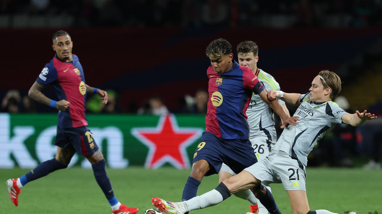 Benfica's Norwegian forward #21 Andreas Schjelderup tackles Barcelona's Spanish forward #19 Lamine Yamal during the UEFA Champions League Round of 16 second leg football match between FC Barcelona and SL Benfica at the Estadi Olimpic Lluis Companys in Barcelona on March 11, 2025. (Photo by LLUIS GENE / AFP)