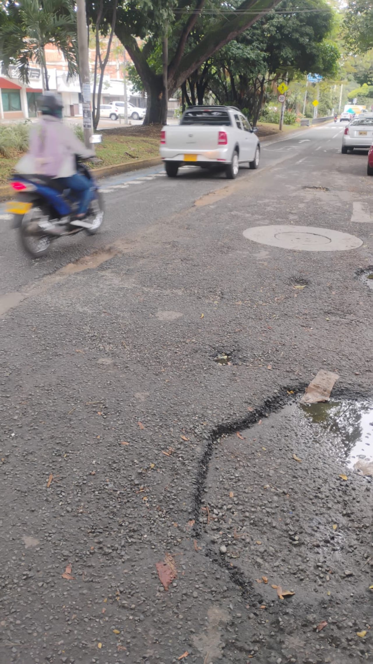 Daños en la calzada dividen los carriles en una vía principal del norte de Cali, según denuncian habitantes del sector La Flora.