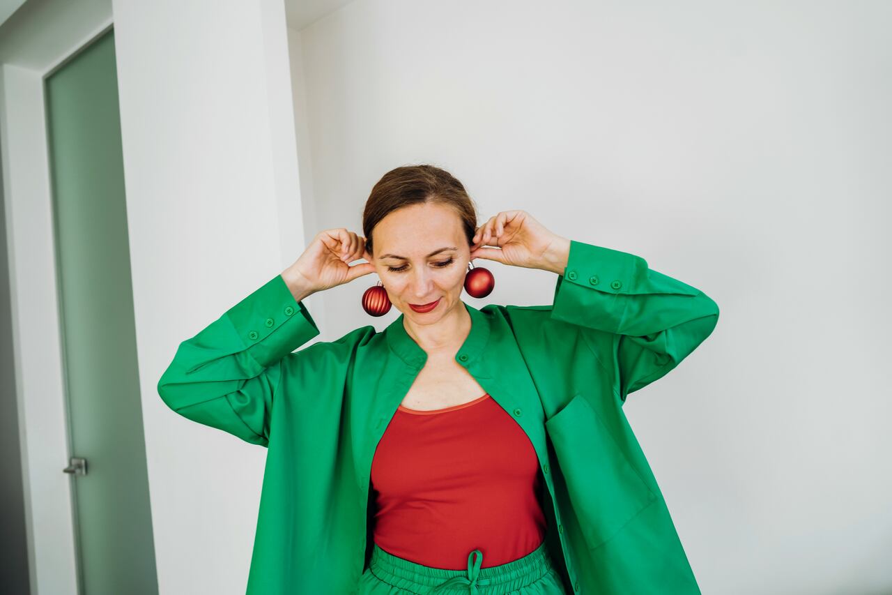 A woman getting dressed in a green and red costume. The concept of a holiday events, new time, making plans for the future, goals and preparation for the New Year, Christmas, St.Patrick 's Day