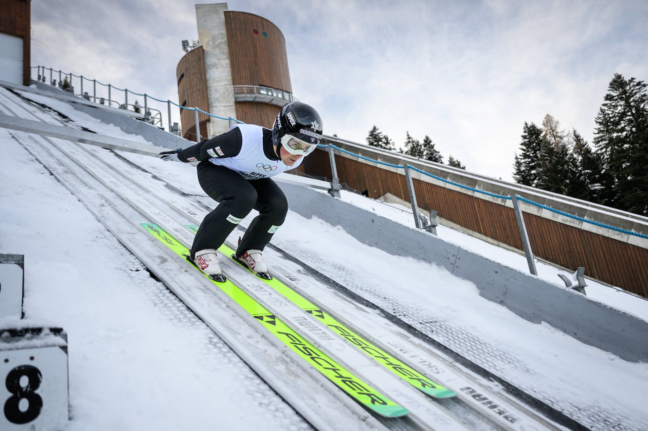 Un joven saltador de esquí se prepara para despegar durante un entrenamiento en la cima del trampolín de Courchevel, que albergará las competiciones de salto de esquí en los Juegos Olímpicos de Invierno de 2030, en Courchevel La Praz, en el centro-este de Francia, el 2 de diciembre de 2025. (Foto de ARNAUD FINISTRE / AFP)