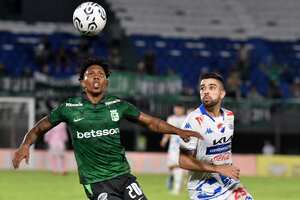 El defensor del Atlético Nacional Joan Castro (L) y el defensor del Nacional Leonardo Rivas (R) luchan por el balón durante el partido de fútbol de ida de la segunda ronda de la Copa Libertadores entre el Nacional de Paraguay y el Atlético Nacional de Colombia en el estadio Defensores del Chaco en Asunción el 21 de febrero. 2024. (Foto de NORBERTO DUARTE/AFP)