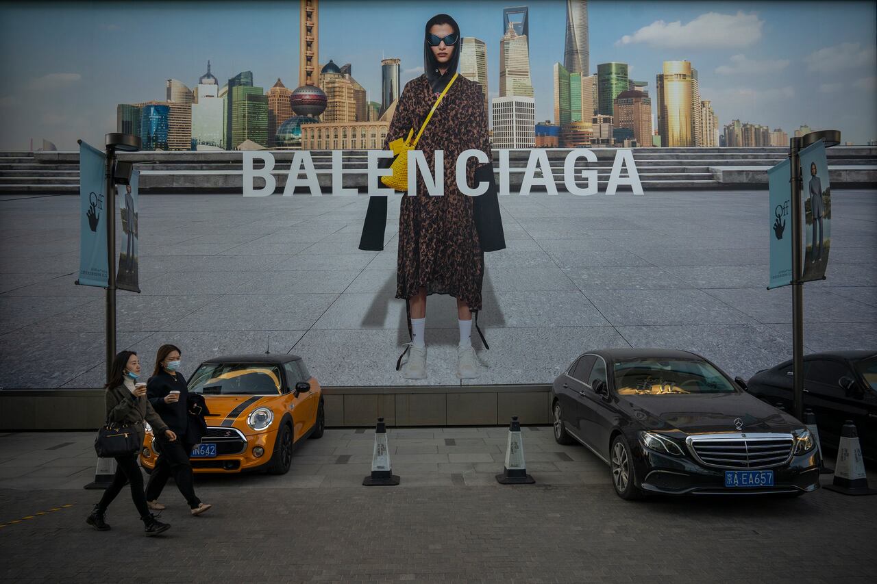 BEIJING, CHINA - OCTOBER 16: People walk in front of a Balenciaga ad on October 16, 2021 in Beijing, China. According to an action plan released on October 14, Beijing has unveiled a series of measures aimed at building the city into an international consumption center over the next five years. (Photo by Andrea Verdelli/Getty Images)