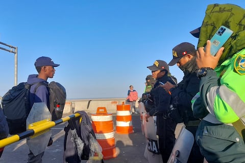 Un grupo de migrantes de varias nacionalidades es detenido en la frontera por policías peruanos en Tacna, Perú, el 13 de abril de 2023. - Decenas de venezolanos, haitianos y ecuatorianos, entre otras nacionalidades, fueron detenidos por policías peruanos en la frontera con Chile , luego de que los migrantes, sin documentos, abandonaran ese país. Foto: AFP