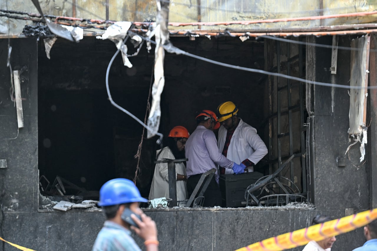 Miembros del equipo forense inspeccionan el lugar tras el incendio que se produjo en un hotel de Nueva Delhi el 3 de junio de 2026.