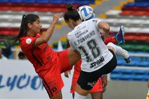 Catalina Usme disputando un esférico con jugadora rival.