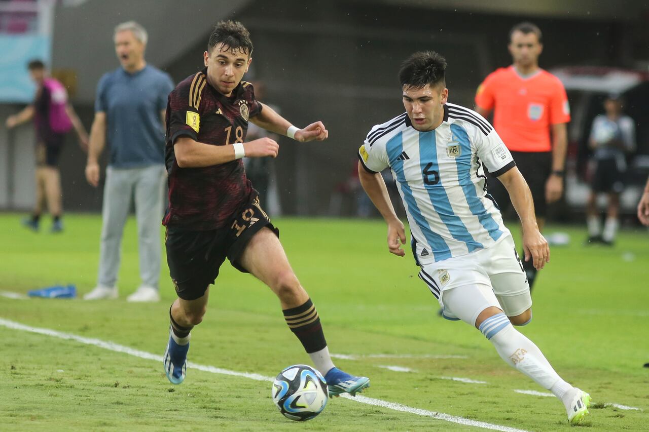El alemán Bilal Yalcinkaya, izquierda, lucha por el balón contra el argentino Juan Villalba durante su partido de semifinales de la Copa Mundial Sub-17 en el estadio Manahan en Surakarta, Java Central, Indonesia, el martes 28 de noviembre de 2023. (Foto AP/John Sumbar)