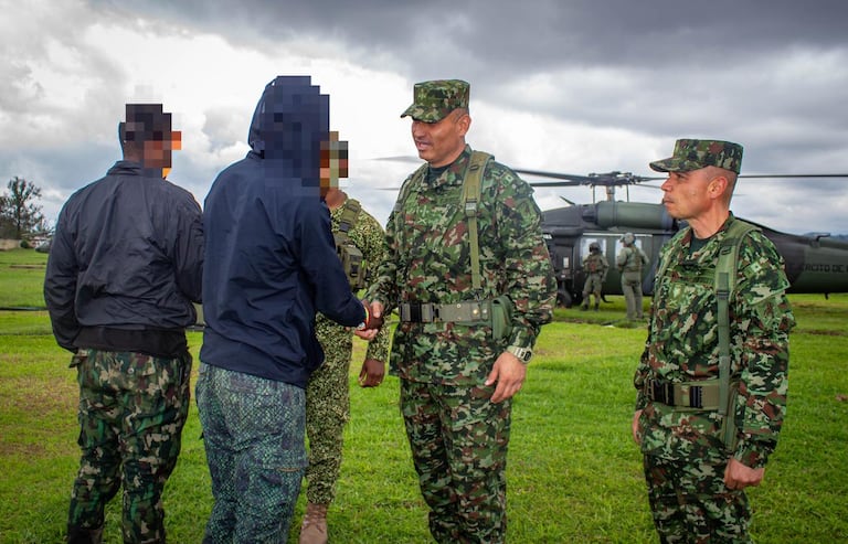 Integrantes del Ejército Nacional de Colombia reciben a dos presuntos integrantes del Frente Jaime Martínez que se sometieron voluntariamente a la justicia en zona rural de López de Micay, departamento del Cauca.