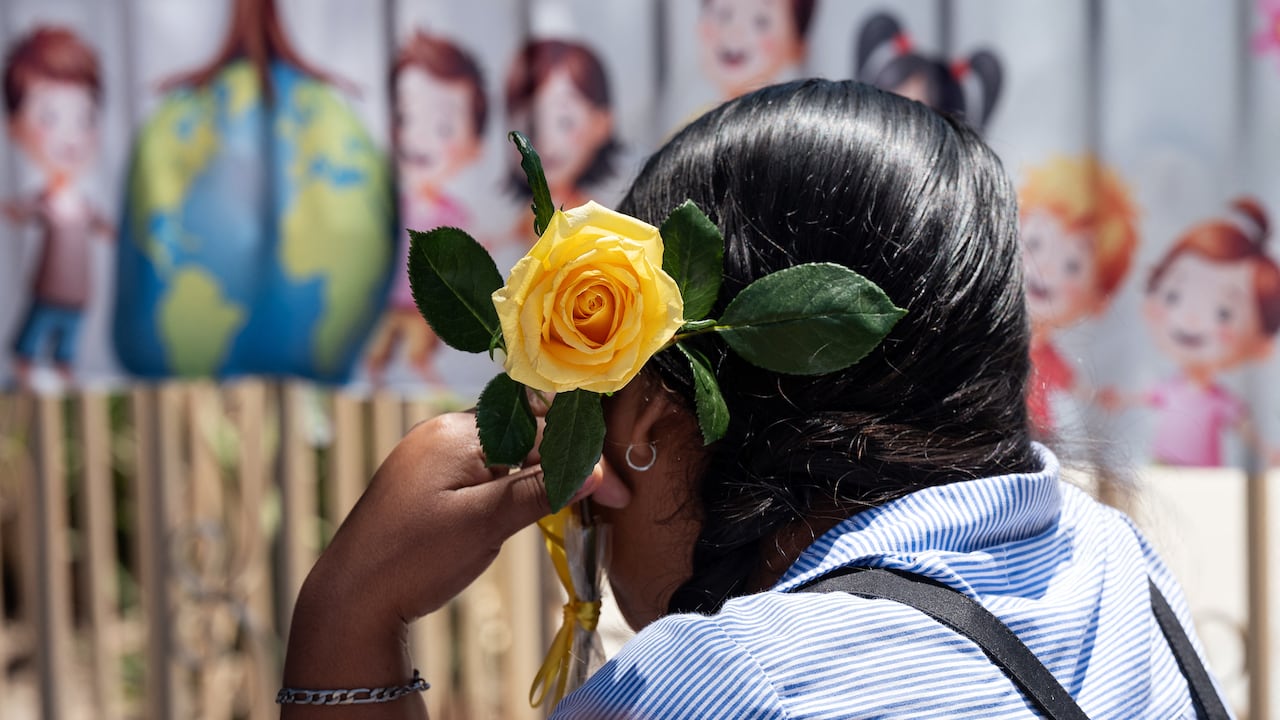A migrant mother holds a yellow rose as she attends mother's Day celebrations at Comunidad de Luz shelter in Tijuana, Baja California state, Mexico on May 9, 2026. (Photo by Guillermo Arias / AFP)