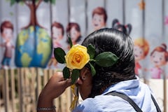 A migrant mother holds a yellow rose as she attends mother's Day celebrations at Comunidad de Luz shelter in Tijuana, Baja California state, Mexico on May 9, 2026. (Photo by Guillermo Arias / AFP)