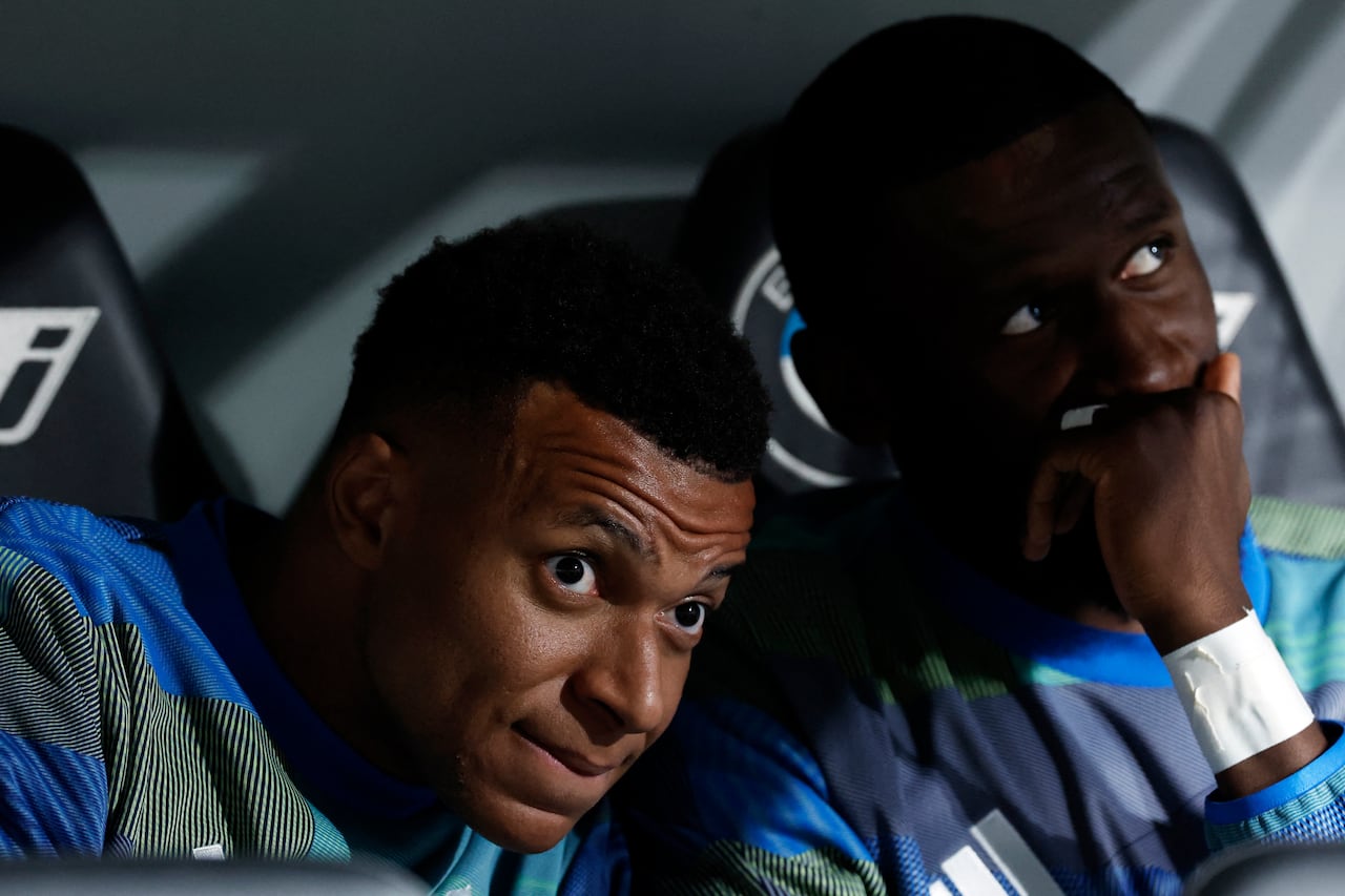 El delantero francés del Real Madrid, Kylian Mbappé (izq.), y el defensa alemán del Real Madrid, Antonio Rüdiger, aparecen en el banquillo antes del partido de la liga española entre el Real Madrid CF y el Real Oviedo en el estadio Santiago Bernabéu de Madrid, el 14 de mayo de 2026. (Foto de Oscar del Pozo / AFP)