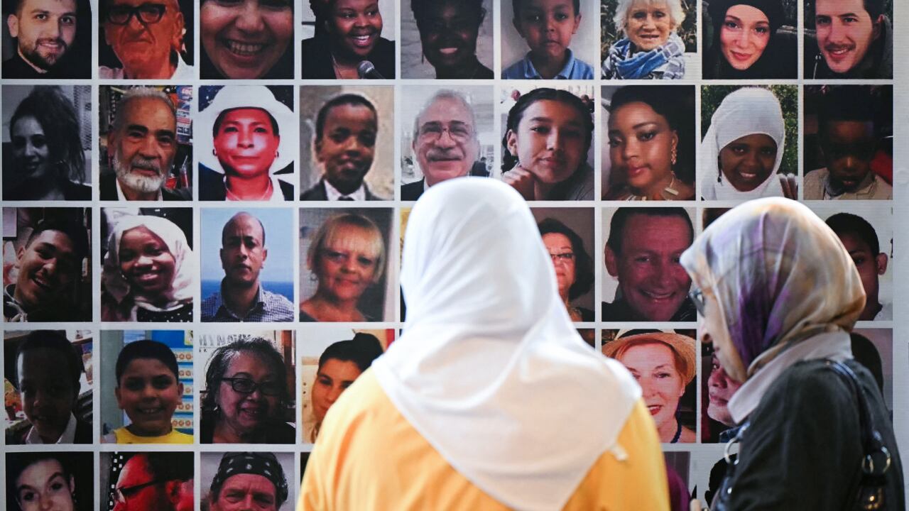 Menana Jabari (izq.), pariente de las víctimas del incendio de la Torre Grenfell, observa una pared con fotografías de las 72 personas que murieron en el incendio, cuando llega para asistir a una conferencia de prensa en el Royal Lancaster Hotel, en Londres, el 4 de septiembre de 2024, tras la publicación de la investigación sobre la Torre Grenfell.
