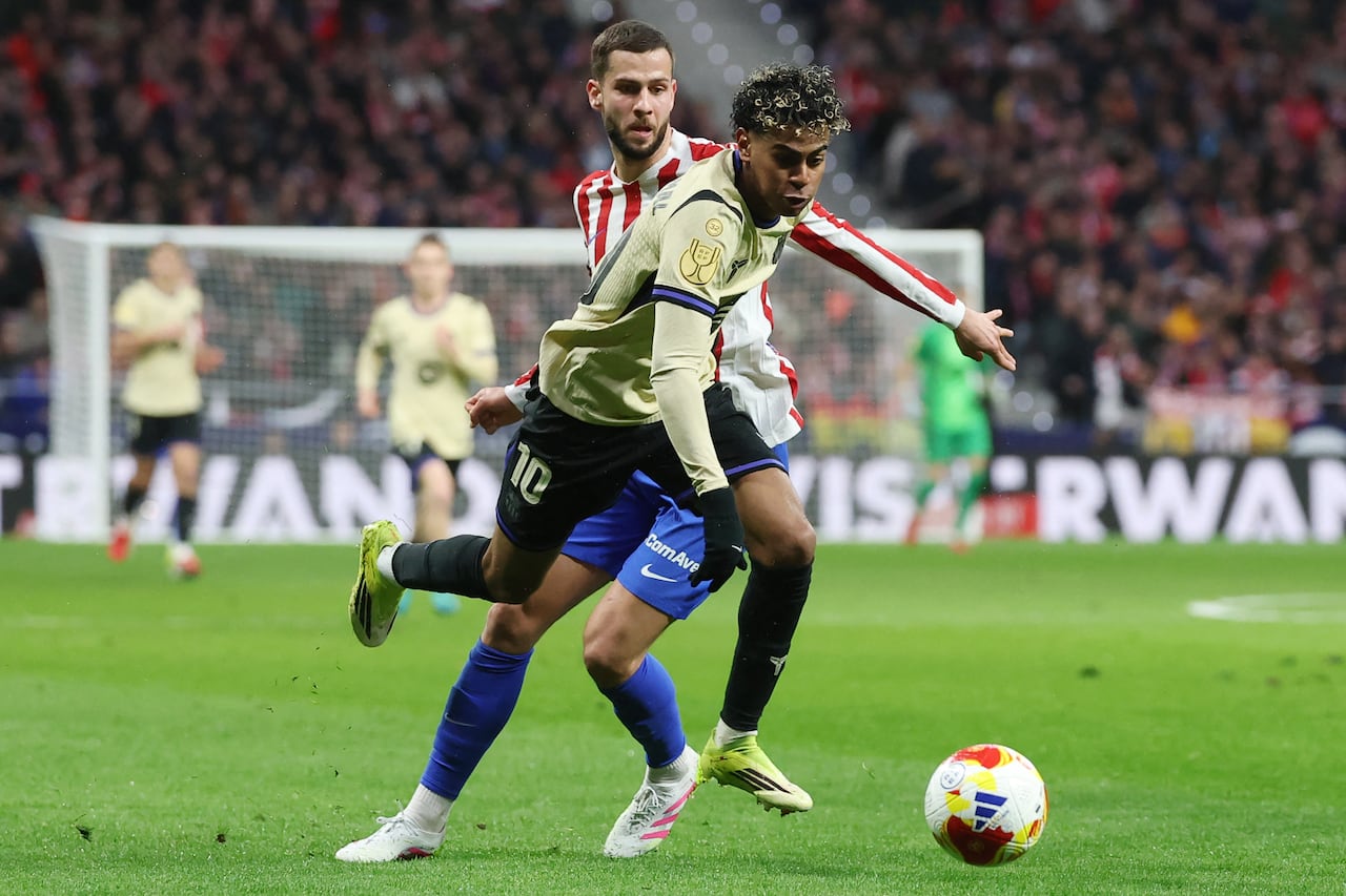 El defensa eslovaco #17 del Atlético de Madrid, David Hancko, y el delantero español #10 del Barcelona, Lamine Yamal, luchan por el balón durante el partido de ida de las semifinales de la Copa del Rey entre el Club Atlético de Madrid y el FC Barcelona en el Estadio Metropolitano de Madrid el 12 de febrero de 2026. (Foto de Pierre-Philippe MARCOU / AFP)