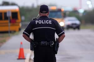 El oficial de policía del Distrito Escolar Independiente de Southside, Rubén Cárdenas, vigila mientras los estudiantes llegan a la Escuela Primaria Freedom, el miércoles 23 de agosto de 2023, en San Antonio. (Foto AP/Eric Gay)