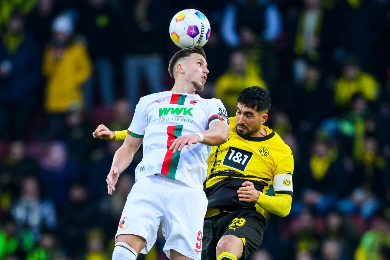Ermedin Demirovic de Augsburgo, izquierda, y Emre Can de Dortmund en acción durante el partido de fútbol de la Bundesliga entre el FC Augsburg y el Borussia Dortmund en el WWK-Arena, Augsburgo, Alemania, el sábado 16 de diciembre de 2023. (Tom Weller/dpa vía AP)