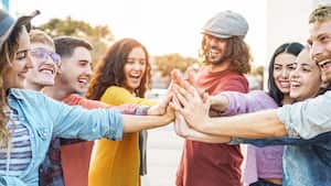 Jóvenes amigos apilando las manos al aire libre - Felices milenarios divirtiéndose uniéndose y celebrando juntos - Amistad, empoderamiento, trabajo en equipo, asociación y concepto de estilo de vida juvenil