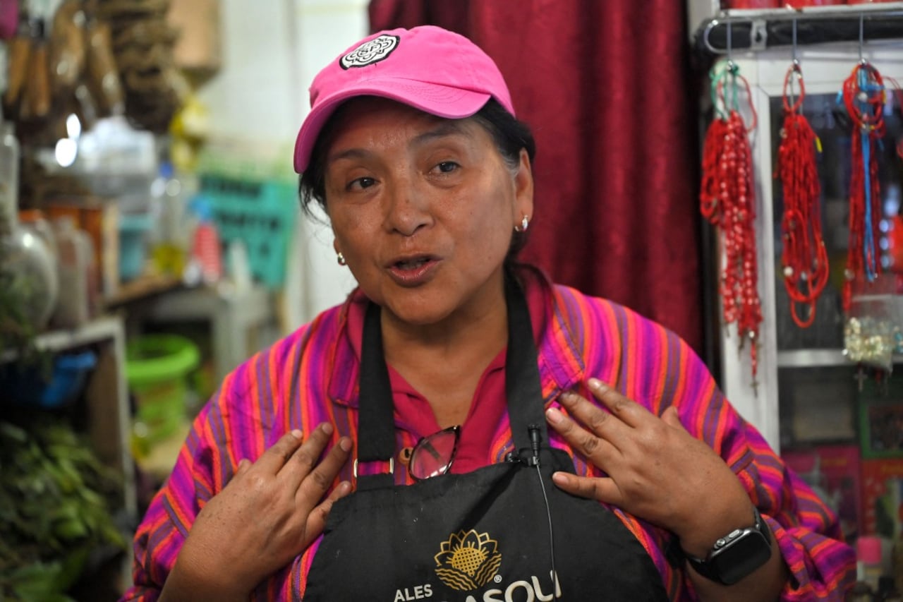 La curandera ecuatoriana Amparo Lugmana coloca un amuleto en el perro Copito durante un ritual de limpieza de energía en el mercado de San Francisco en Quito el 17 de mayo de 2026. Las curanderas limpian a las mascotas de energía negativa en un mercado de Ecuador.