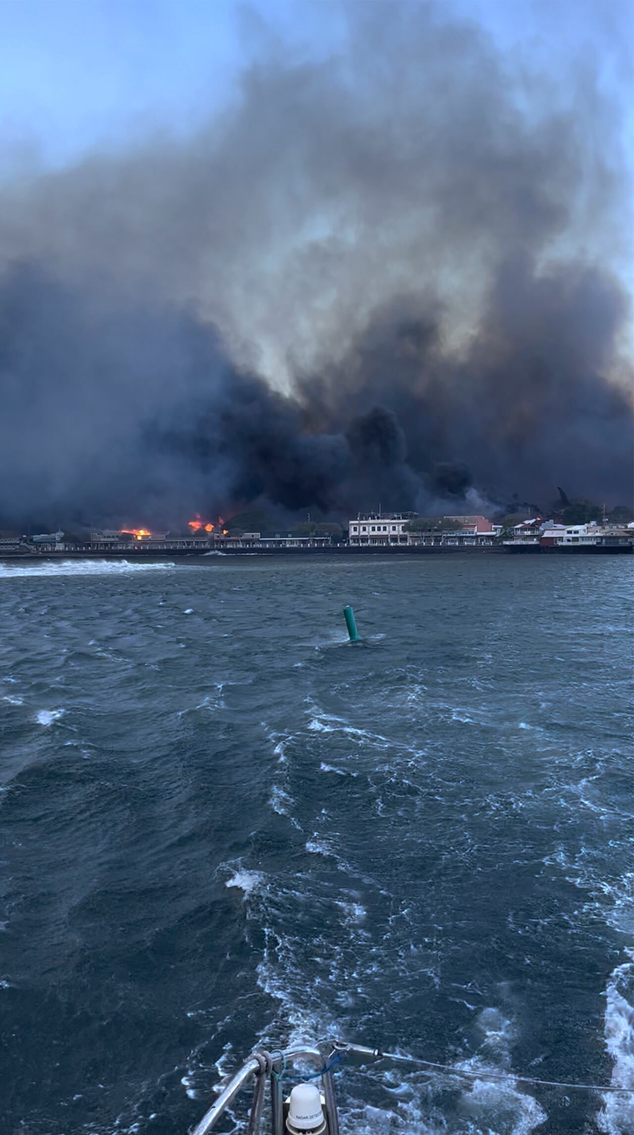En esta foto proporcionada por Brantin Stevens, el humo llena el aire de los incendios forestales en el puerto de Lahaina el martes 8 de agosto de 2023 en Hawái.