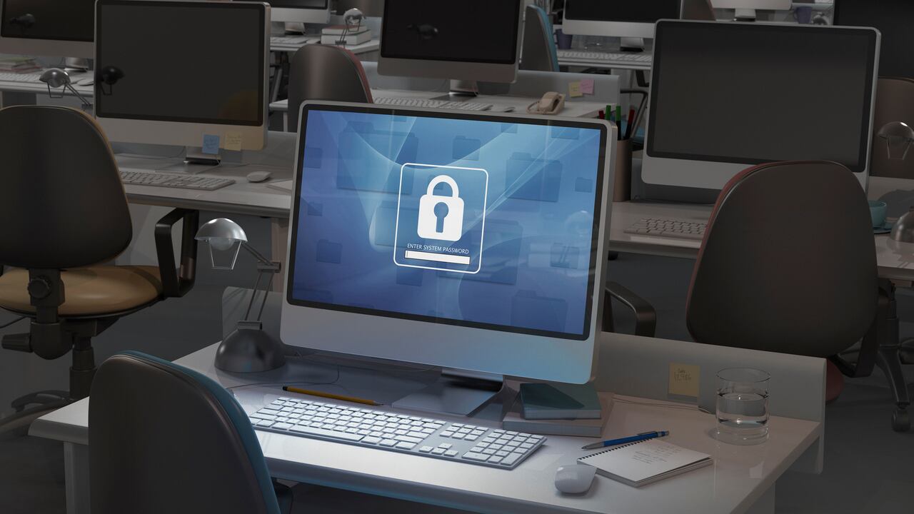 Computadora en oficina oscura, se requiere ingreso de contraseña - Imagen de referencia