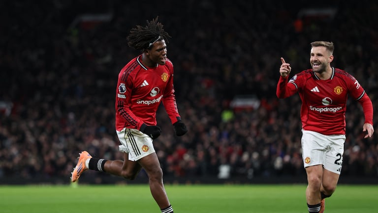 El defensa danés número 13 del Manchester United, Patrick Dorgu (izq.), celebra con el defensa inglés número 23 del Manchester United, Luke Shaw (der.), tras anotar el primer gol del partido de la Premier League inglesa entre el Manchester United y el Newcastle United en Old Trafford, en Manchester, noroeste de Inglaterra, el 26 de diciembre de 2025. (Foto de Darren Staples / AFP)