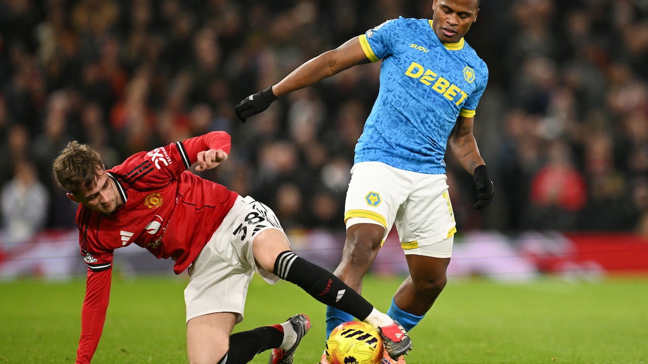 El centrocampista inglés #38 del Manchester United, Jack Fletcher (izq.), intenta taclear al delantero colombiano #10 del Wolverhampton Wanderers, Jhon Arias (der.), durante el partido de la Premier League inglesa entre el Manchester United y el Wolverhampton Wanderers en Old Trafford, en Manchester, noroeste de Inglaterra, el 30 de diciembre de 2025. (Foto de Oli SCARFF / AFP)