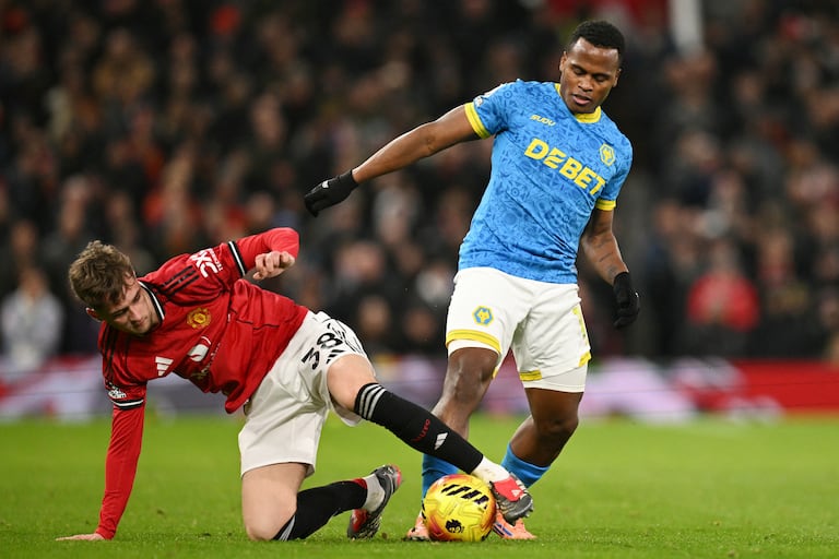 El centrocampista inglés #38 del Manchester United, Jack Fletcher (izq.), intenta taclear al delantero colombiano #10 del Wolverhampton Wanderers, Jhon Arias (der.), durante el partido de la Premier League inglesa entre el Manchester United y el Wolverhampton Wanderers en Old Trafford, en Manchester, noroeste de Inglaterra, el 30 de diciembre de 2025. (Foto de Oli SCARFF / AFP)