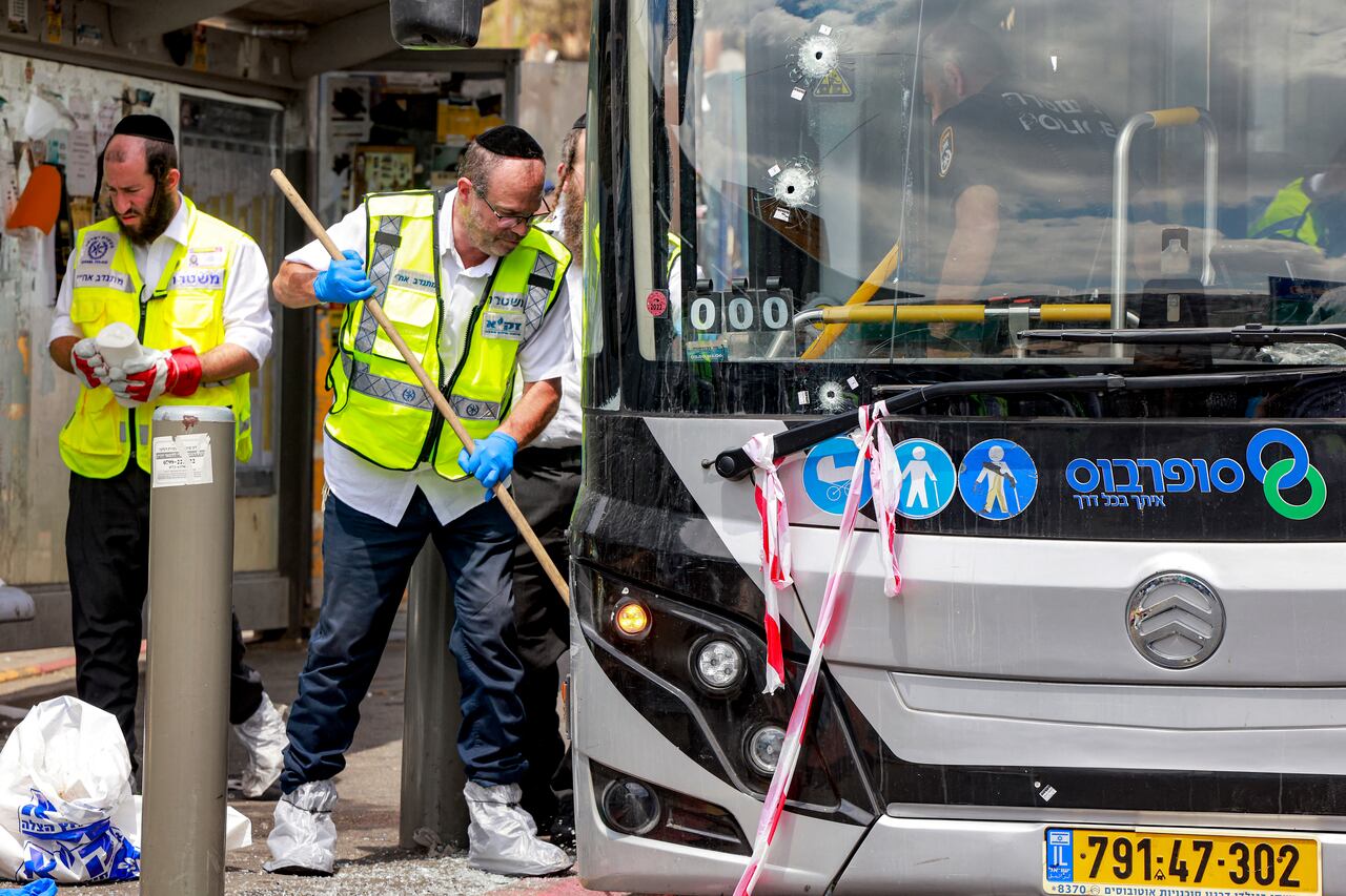 Miembros de los servicios de emergencia ZAKA de Israel recogen muestras en el lugar de un tiroteo en el cruce de la carretera Ramot, en Jerusalén Oriental, anexionada por Israel, el 8 de septiembre de 2025.