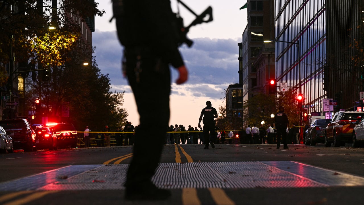 Un agente de policía asegura la zona, mientras agentes del orden visitan la escena del tiroteo en el centro de Washington, D.C.