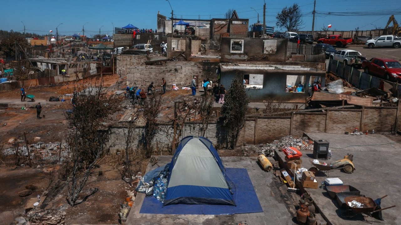 Residentes limpian escombros tras los devastadores incendios forestales que asolaron la zona el 3 de enero en Punta de Parra, cerca de Concepción, Chile, el 21 de enero de 2026. La policía del centro-sur de Chile arrestó a un hombre como sospechoso de iniciar uno de los recientes incendios forestales que causaron la muerte de 20 personas y arrasaron barrios enteros