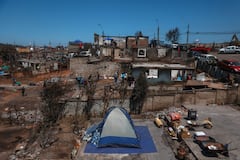 Residentes limpian escombros tras los devastadores incendios forestales que asolaron la zona el 3 de enero en Punta de Parra, cerca de Concepción, Chile, el 21 de enero de 2026. La policía del centro-sur de Chile arrestó a un hombre como sospechoso de iniciar uno de los recientes incendios forestales que causaron la muerte de 20 personas y arrasaron barrios enteros