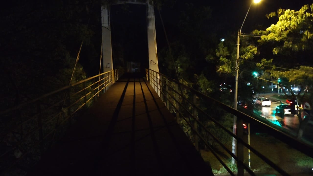 La presencia de árboles y la escasa iluminación dificultan el tránsito seguro de peatones en este corredor de alta circulación del sur de Cali.