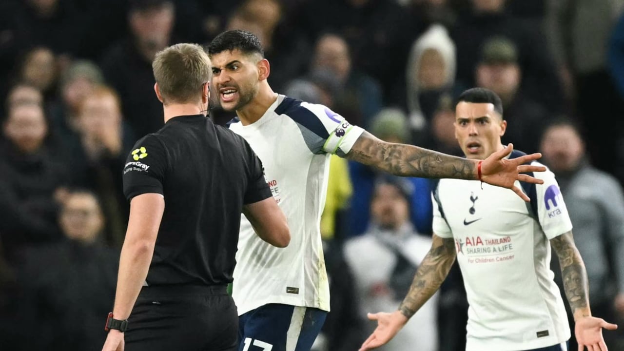 El defensa argentino #17 del Tottenham Hotspur, Cristian Romero (C), y el defensor español #23 del Tottenham Hotspur, Pedro Porro (D), protestan con el árbitro John Brooks (I) durante el partido de fútbol de la Premier League inglesa.