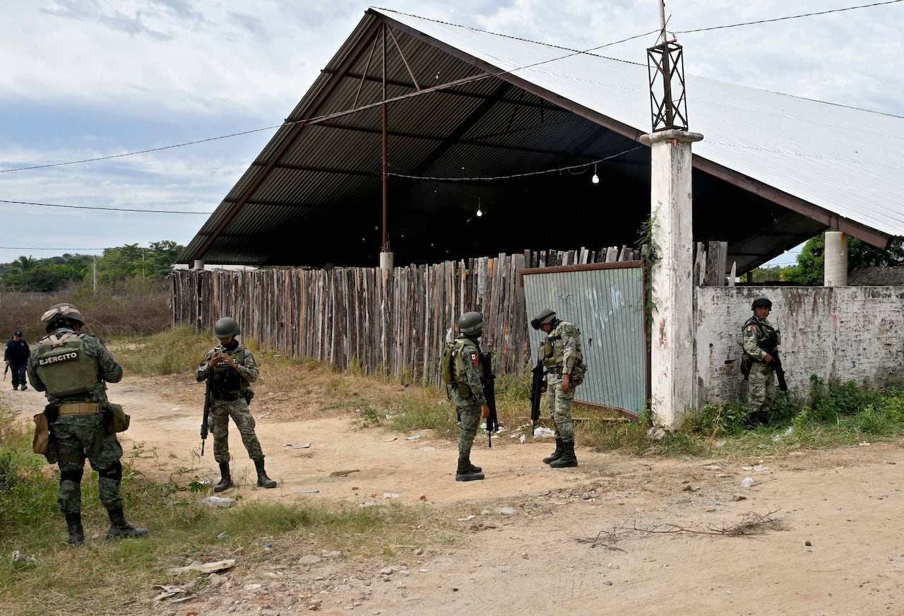 Los soldados hacen guardia e inspeccionan el área afuera de un palenque, donde se llevan a cabo peleas de gallos, un día después de que cinco personas murieran y 20 resultaran heridas en un ataque de hombres armados desconocidos durante una pelea de gallos, en Petatlán, estado de Guerrero, México, el 7 de enero. 2024. El ataque en Petatlán el sábado se produce mientras las autoridades mexicanas están investigando el asesinato de cinco personas relacionado con el cártel de Buenavista, también en el estado de Guerrero, el viernes. Guerrero es uno de los estados más pobres y violentos de México, debido a los enfrentamientos entre narcotraficantes rivales y fuerzas de seguridad. (Foto de Francisco ROBLES/AFP)