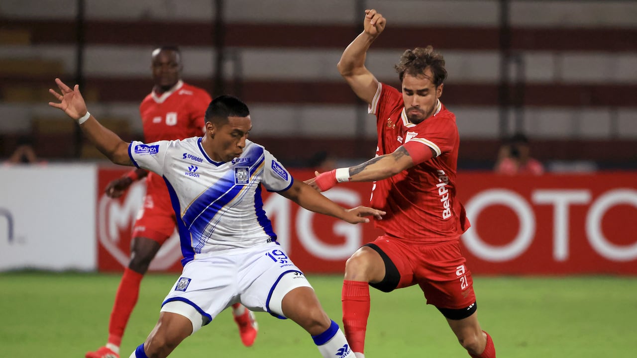 El defensa número 19 de Alianza Atlético, Jesús Mendieta, y el delantero número 21 de América de Cali, Tomás Ángel, luchan por el balón durante el partido de la fase de grupos de la Copa Sudamericana entre Alianza Atlético de Perú y América de Cali de Colombia en el estadio Miguel Grau del Callao en Bellavista, región del Callao, Perú, el 6 de mayo de 2026. (Foto de Connie FRANCE / AFP)
