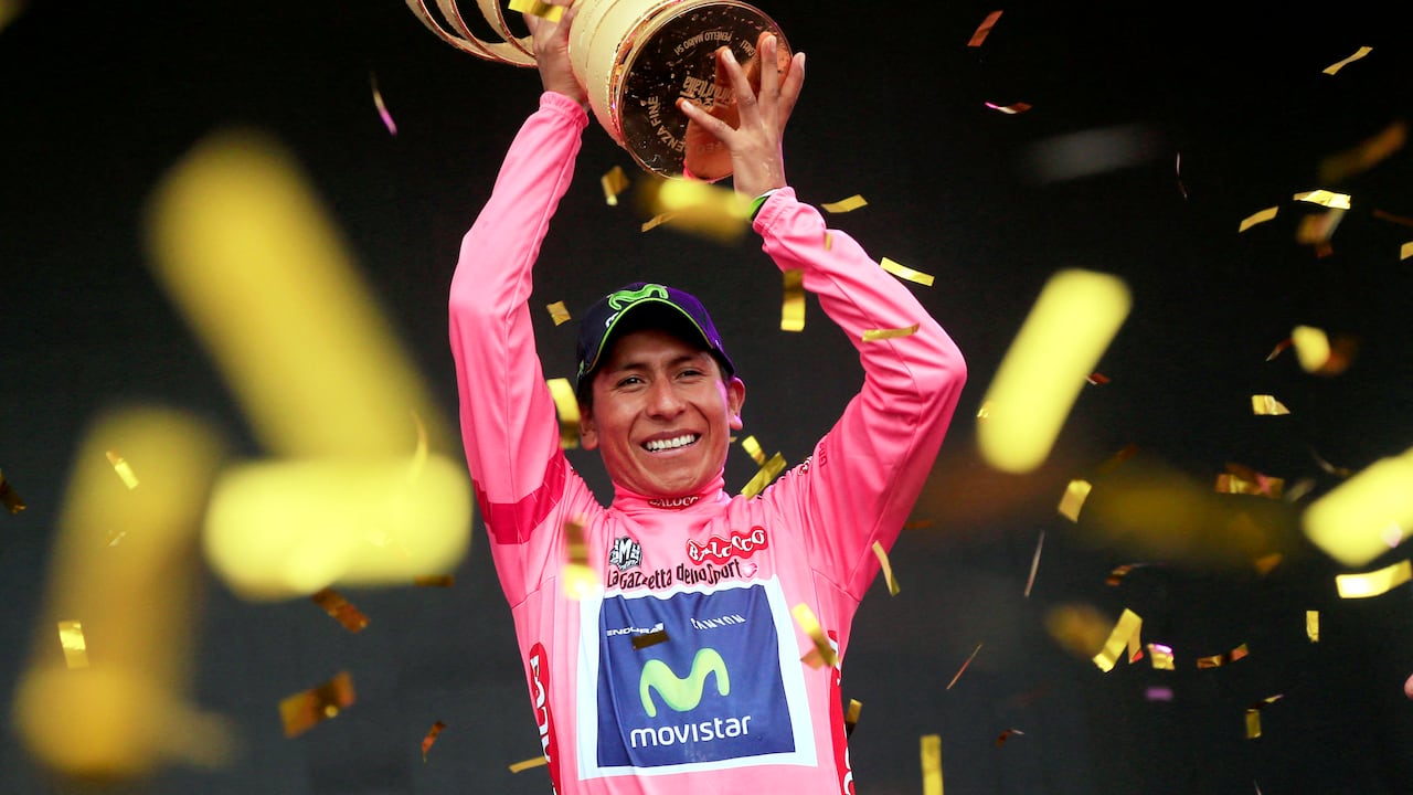El colombiano Nairo Quintana celebra en el podio con el trofeo y el maillot rosa de líder de la clasificación general, tras ganar la 97ª carrera ciclista del Giro de Italia, al final de la 21ª y última etapa, a 172 kilómetros de Gemona. a Trieste, el 1 de junio de 2014 en Trieste. AFP PHOTO/LUK BENIES (Foto de LUK BENIES / AFP)