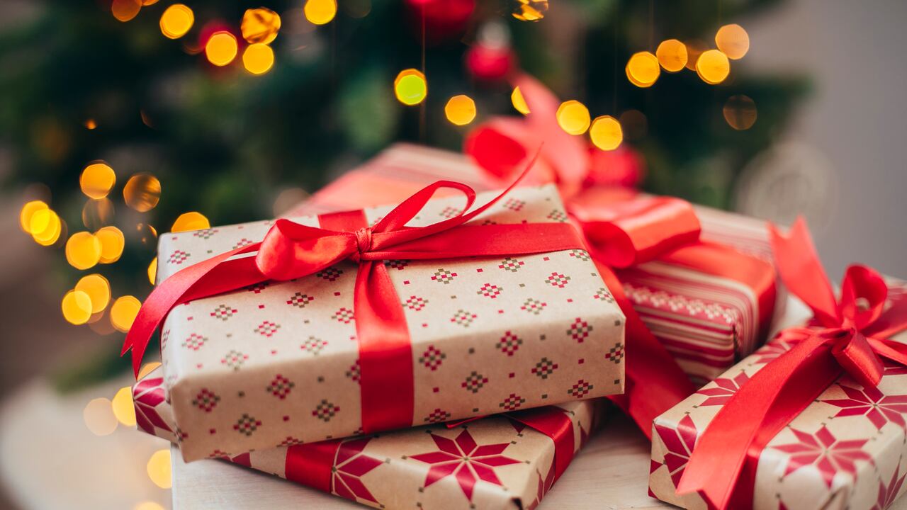 Beautiful Christmas gift boxes near fir tree. Merry Christmas and Happy New Year