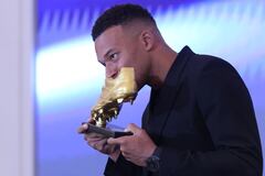 El delantero francés del Real Madrid, Kylian Mbappé, besa su trofeo tras recibir la Bota de Oro europea 2024-25.