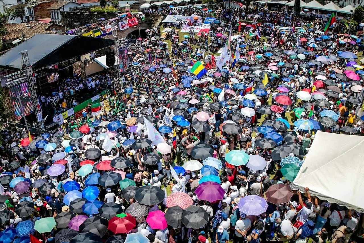 Con sombrillas para protegerse del sol, comunidades indígenas, campesinas y afrodescendientes escuchan el discurso centrado en la defensa de los derechos territoriales.