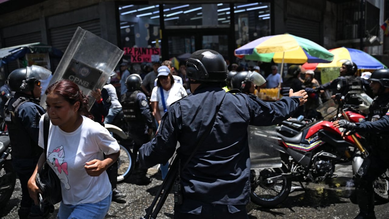 Agentes de policía se despliegan mientras opositores al gobierno de la presidenta interina venezolana Delcy Rodríguez se manifiestan en Caracas