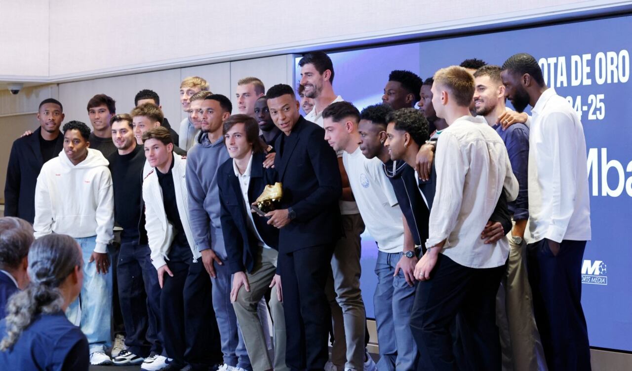 El delantero francés del Real Madrid, Kylian Mbappé (C), posa con sus compañeros de equipo después de recibir la Bota de Oro europea 2024-25, premio que honra al máximo goleador del año.