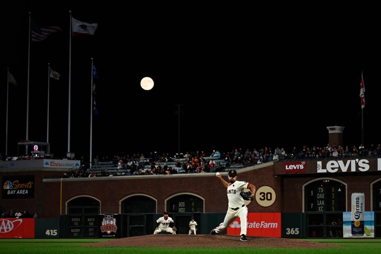 Una superluna azul se eleva sobre el campo mientras Jordan Hicks # 12 de los Gigantes de San Francisco lanza un lanzamiento contra los Medias Blancas de Chicago en la novena entrada en Oracle Park el 19 de agosto de 2024 en San Francisco, California.